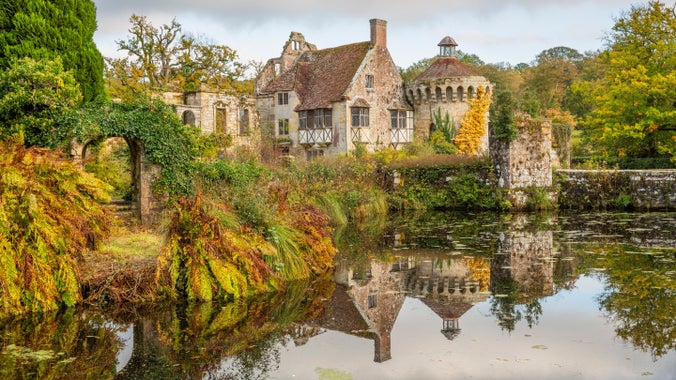 View of the Old Castle ruins through the autumnal garden at Scotney Castle, Kent